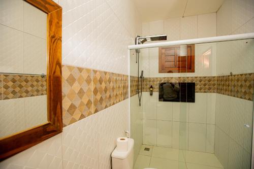 a bathroom with a shower and a toilet and a mirror at Pousada Sítio Machado in Viçosa do Ceará