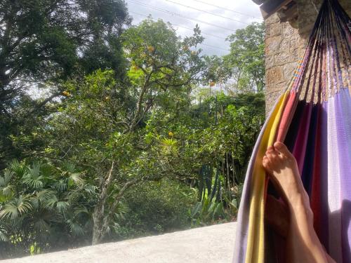 a person in a hammock looking out of a window at El Refugio de los Ángeles in San Antonio del Tequendama