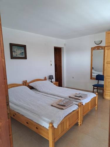a bedroom with two beds with a mirror and a chair at Дядо Цоньовата къща самостоятелен имот с басейн in Sevlievo