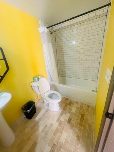 a bathroom with a white toilet and a sink at Felton Motel in Breezewood
