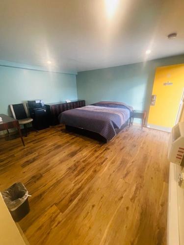 a bedroom with a bed and a wooden floor at Felton Motel in Breezewood