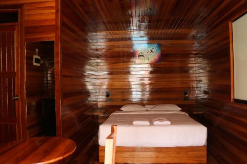 a bedroom with a bed in a wooden room at Alpinas Natural Suites in Lunahuaná
