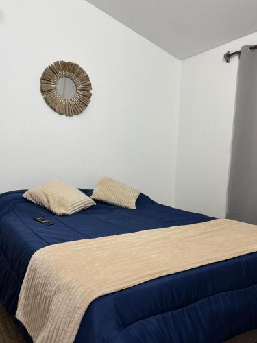 a bedroom with a blue bed with a mirror on the wall at Paraiso Yapeyù in Yapeyú