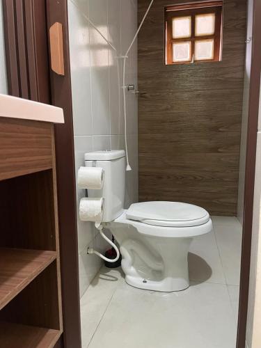 a bathroom with a white toilet in a room at Pousada NASCER DO SOL in Bertioga