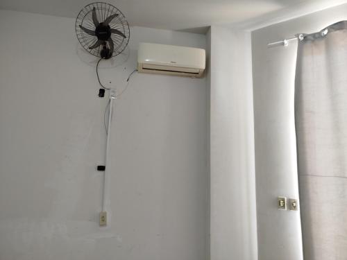 a room with a fan on the wall at Studio Apto Central próximo a Orla in Fatima do Sul