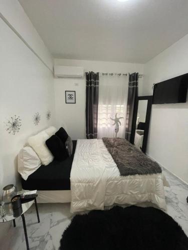 a bedroom with a bed with a black and white comforter at Modern Ocean View Apartment in Upper Prince's Quarter