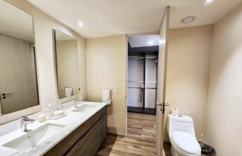 a bathroom with two sinks and a toilet at Departamento Andares in Guadalajara