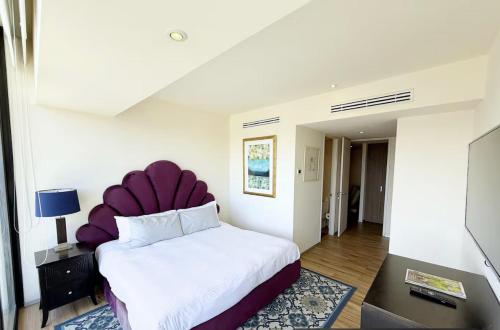 a bedroom with a large bed with a purple headboard at Departamento Andares in Guadalajara