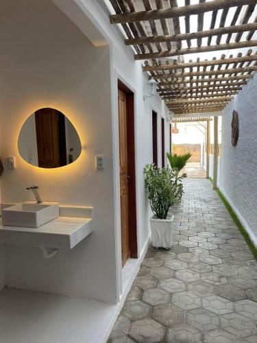 a bathroom with a sink and a mirror on the wall at Casa Carnaubas in Icapuí