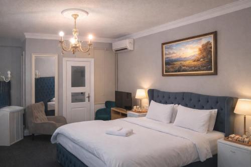 a hotel room with a large bed and a chandelier at valide-maide hotel in Istanbul
