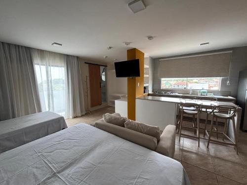 a hotel room with two beds and a kitchen at Flat com vista mar in Mucuri