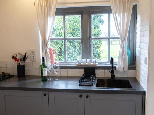 a kitchen counter with a sink and a window at Uilenhof in Epe