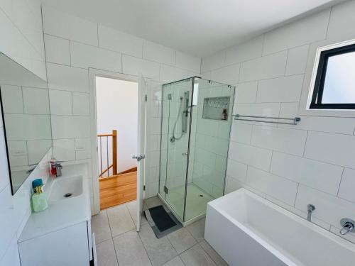 a bathroom with a shower and a tub and a sink at Quiet and Cozy corner in Braybrook