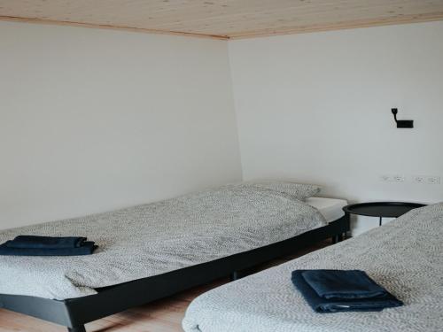 two beds in a room with two tables at Uilenhof in Epe