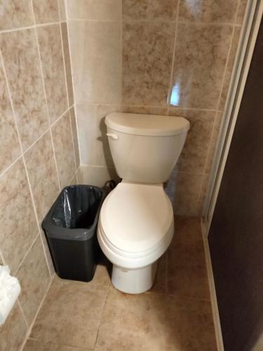 a bathroom with a toilet and a trash can at Hotel Aldea Cruzo'ob in Felipe Carrillo Puerto