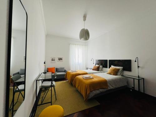 a bedroom with two beds and a mirror at Portas Residence, Quartos & Suites - Ponta Delgada City Center in Ponta Delgada