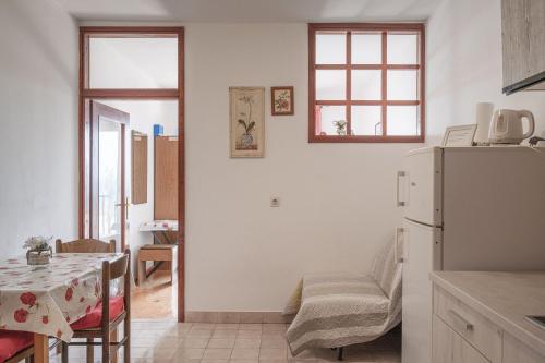 a kitchen with a white refrigerator and a table at Apartments by the sea Prizba, Korcula - 12648 in Prizba