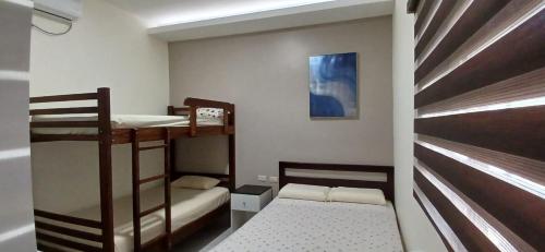 a small room with two bunk beds and a bed at Suites del Pacífico in Salinas