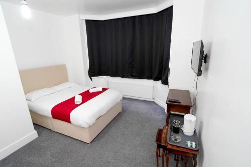 a hotel room with a bed and a television at Birchwood-Lodge in Horley