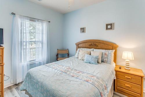 a bedroom with a bed with a wooden headboard and a window at Condo w/ Pool Access, 1 Mi to Cherry Grove Beach in Myrtle Beach