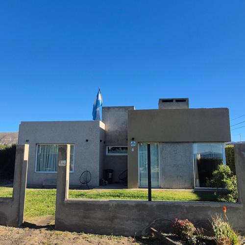 ein Haus mit einer Flagge auf dem Dach in der Unterkunft OLIEMI in El Calafate
