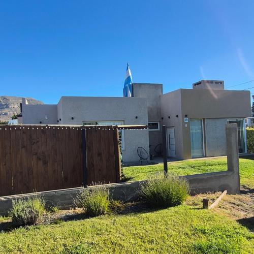 ein Haus mit einem Zaun davor in der Unterkunft OLIEMI in El Calafate