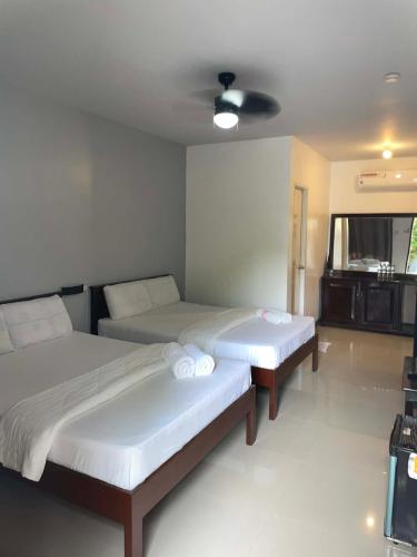 a room with two beds and a tv at Garden Village Resort in Moalboal