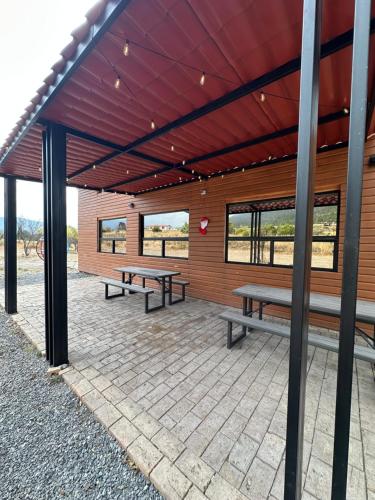 a pavilion with two benches in a building with windows at La Casona del atardecer in San Antonio de las Alzanas