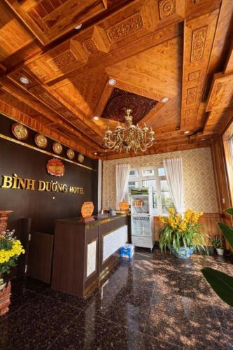 a kitchen with a wooden ceiling with a chandelier at Bình Dương Đà Lạt Hotel in Da Lat