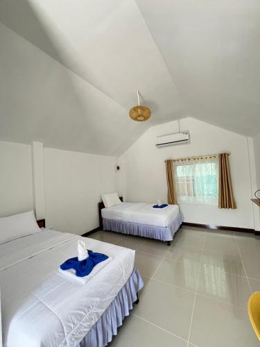 a bedroom with two beds and a ceiling at บ้านสวนชมจันทร์ กำแพงแสน in Ban Song Hong