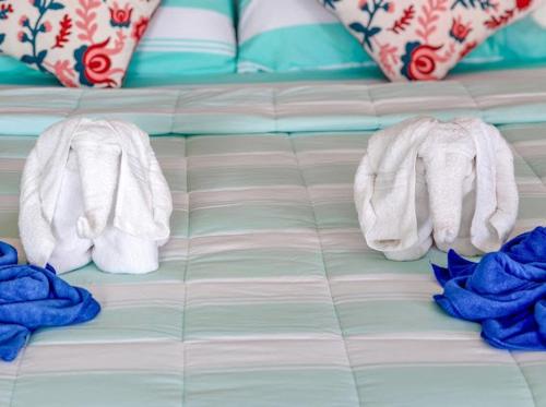 a pair of socks and towels on a bed at บ้านสวนชมจันทร์ กำแพงแสน in Ban Song Hong