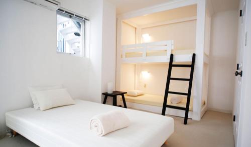 a bedroom with a bunk bed and a ladder at ラナイ ホテルアンドドミトリー in Naha