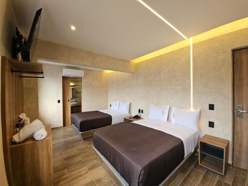 a hotel room with two beds and a cat on the wall at Hotel Único La Villa in Mexico City