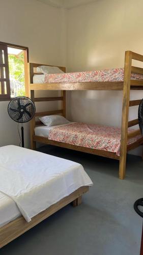 a room with three bunk beds and a fan at Mi refugio in Moñitos