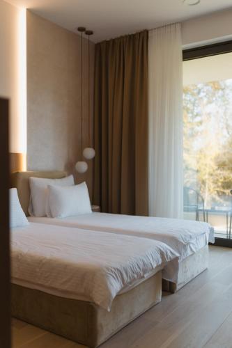 ein Schlafzimmer mit einem großen Bett und einem großen Fenster in der Unterkunft Hotel Dado in Grude