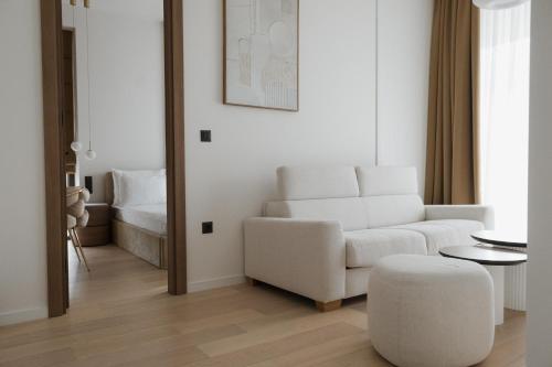 ein Wohnzimmer mit einem weißen Sofa und einem Hocker in der Unterkunft Hotel Dado in Grude