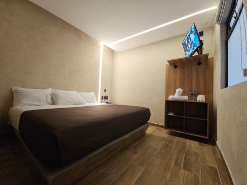 a bedroom with a bed in a room with a window at Hotel Único La Villa in Mexico City