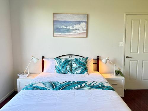 a bedroom with a white bed with blue pillows at Cozy Share Suite in Coopers Plains - Double Room with Private Bathroom in Brisbane