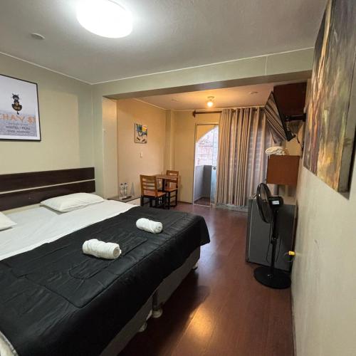 a bedroom with a bed with two towels on it at Miraflores Thay Colonial in Lima