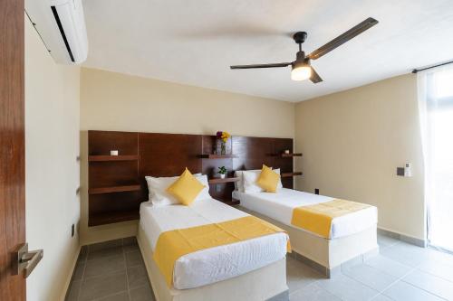 a bedroom with two beds and a ceiling fan at iKAL 93 Casa Nido de Mar 9 Persons Occupancy, Pool, 7 Beds in Nuevo Vallarta