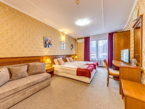 a hotel room with a bed and a couch at Хотел Елит Релакс in Devin