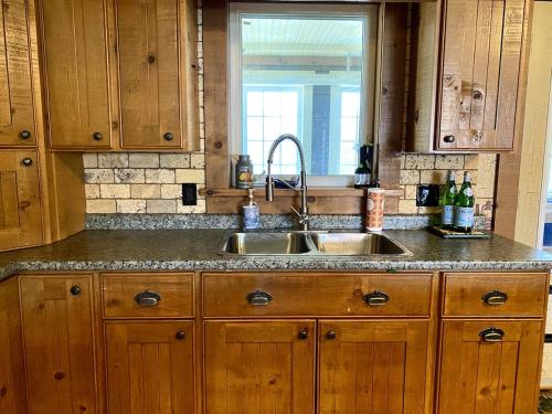 a kitchen with wooden cabinets and a sink at Cajun Cabin Private Nature Resort in Minden