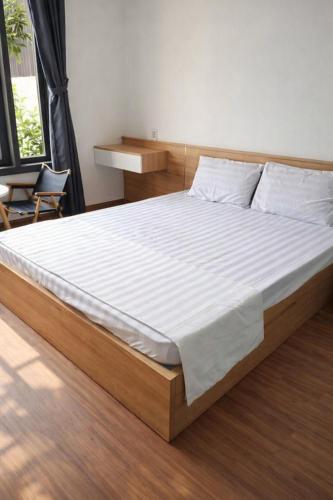 a bedroom with a large bed with white sheets at Khôi Đại Hotel - gần sân bay Buôn Ma Thuột, near Buon Ma Thuot Airport in Buon Ma Thuot