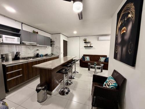 a kitchen with a counter and some chairs in a room at Hermoso y Comfortable Departamento 15 min del Aeropuerto in Guadalajara