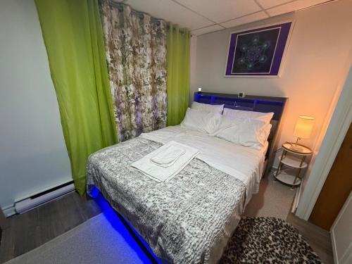 a small bedroom with a bed with a green curtain at Appartement Cool à Longueuil Plan A in Longueuil