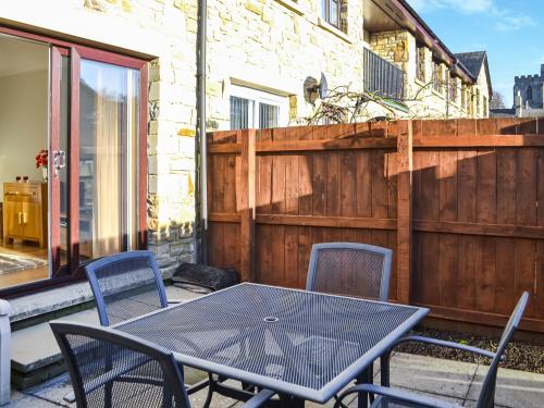a table and chairs on a patio with a fence at The Malt House in Rothbury