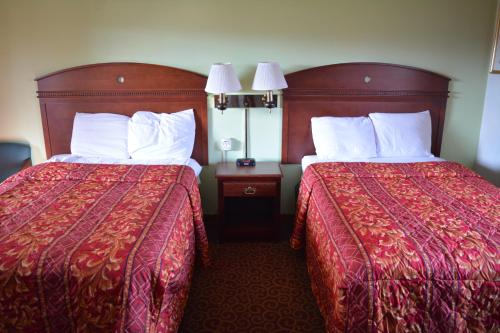 a hotel room with two beds with red sheets and white pillows at WYE Motor Lodge Duncansville - Altoona in Duncansville