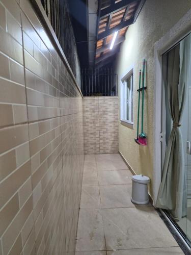 a hallway of a room with a tile wall at Casinha Encantada da MaLu in Itapema