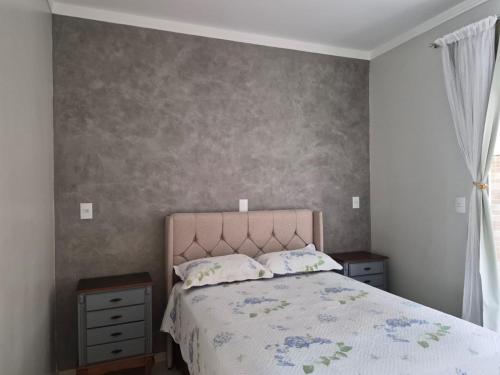 a bedroom with a large bed and a window at Casinha Encantada da MaLu in Itapema