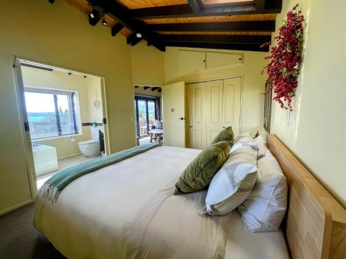 a bedroom with a large bed with pillows at TekapoB2 Lakeview Apartment in Lake Tekapo